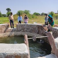 people around a well fetching water